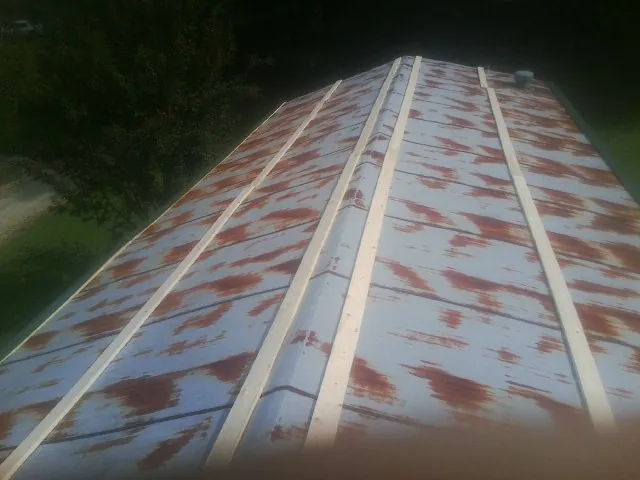 Rusted metal roof panels with new wood purlins before replacement — Storm Damage Roof Repair in Annabella by Roofing Brothers