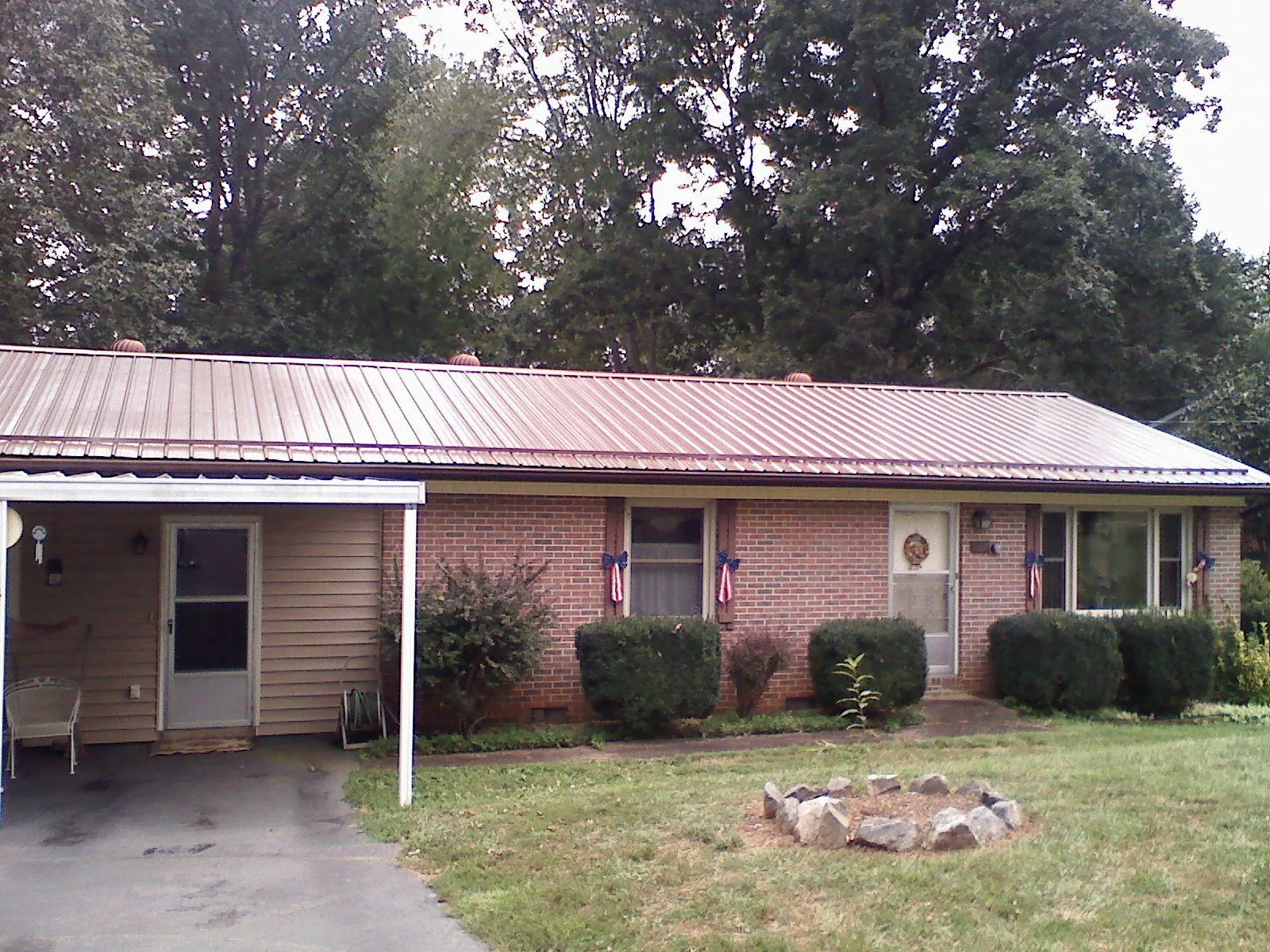 Bronze metal roof and carport on a brick ranch home — Roof Repair work by our crew in Annabella