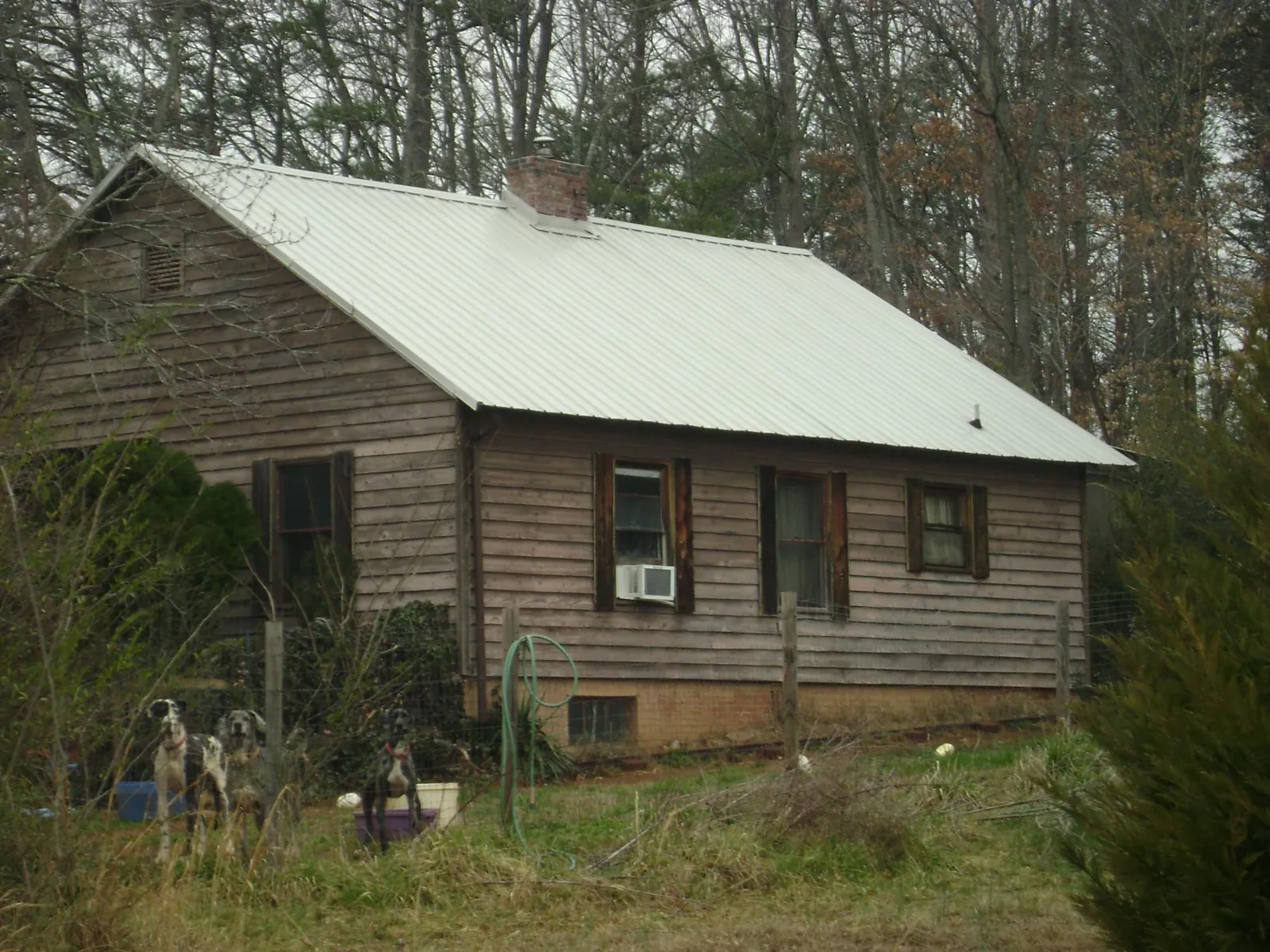 White metal roof on an old wood sided farmhouse, from a Metal Roof Installation job in Annabella